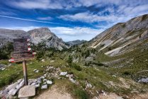Four hikers beyond a Hiking signpost, Dolomites, Fanes-Sennes-Braies Natural Park, South Tyrol, Italy — Stock Photo