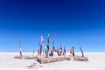 Various flags on Uyuni Salt Flat, Altiplano, Bolivia — Stock Photo