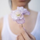 Femme tenant une fleur fleurie — Photo de stock