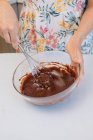 Mujer de pie en cocina batiendo pastel de masa - foto de stock