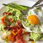 Avocado with cottage cheese  and egg on rye bread toast with tomato, spring onion and asparagus — Stock Photo