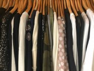 Primer plano de la ropa colgada en un armario - foto de stock