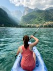 Vista trasera de una joven en kayak, lago Molveno, Trentino, Italia - foto de stock