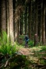 Young woman riding a mountain bike along a trail in the forest, Salzburg, Austria — Stock Photo