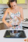 Mulher derramando massa bolo em uma lata de bolo — Fotografia de Stock