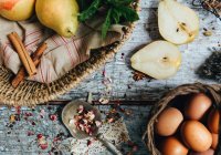 Груши, яйца и коричные палочки на деревянном столе — стоковое фото