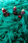 Vue aérienne de trois femmes réparant des filets de pêche, Vietnam — Photo de stock