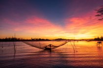 Silhouette eines Fischers bei der Überprüfung seiner Netze bei Sonnenaufgang, Vietnam — Stockfoto