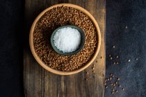 Bowl of salt on top of a bowl of buckwheat — Stock Photo