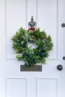 Corona de Navidad colgando en una puerta principal, Inglaterra, Reino Unido - foto de stock