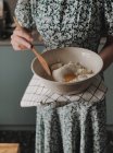 Woman standing in a kitchen making a cheesecake — Stock Photo