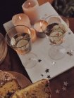 Vinho branco e panettone ao lado de velas — Fotografia de Stock