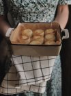 Жінка тримає тарілку з домашніми сирниками — стокове фото