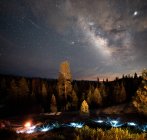 Milchstraße und Sternschnuppe über festlichem Licht und Lagerfeuer, Kings Canyon, Sequoia National Park, Kalifornien, USA — Stockfoto