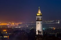 UC Berkeley Campanile Clock Tower und Bay Bridge in der Dämmerung, Berkeley, Kalifornien, USA — Stockfoto