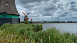 Moulins à vent traditionnels le long du fleuve Zaan, Zaanse Schans, Zaandam, Hollande-Septentrionale, Pays-Bas — Photo de stock