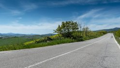 Straight road through rural landscape, Volterra, Pisa, Tuscany, Italy — Stock Photo