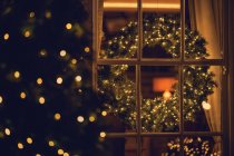 View through a window of a Christmas wreath in a living room — Stock Photo