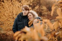 Mutter steht im Herbstwald und umarmt ihren Sohn, Niederlande — Stockfoto