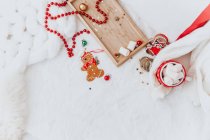 Lebkuchen, Marshmallows und Weihnachtsdekoration auf weißem Hintergrund — Stockfoto