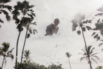 Vista de baixo ângulo de um menino sendo jogado no ar em uma piscina, Havaí, EUA — Fotografia de Stock