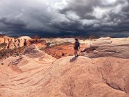 Woman hiking in Valley of Fire State Park with storm approaching, Nevada, USA — Stock Photo