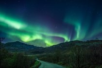 Luci settentrionali sulla strada di montagna, Flakstad, Lofoten, Nordland, Norvegia — Foto stock