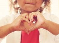 Girl making a heart shape with her hands — Stock Photo
