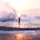 Mujer parada en una piscina de marea al atardecer, Laguna Beach, California, EE.UU. - foto de stock