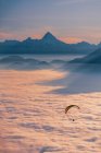 Silhouette di un parapendio che vola sopra il tappeto delle nuvole al tramonto, Gaisberg, Salisburgo, Austria — Foto stock