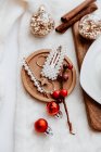Christmas decoration with gingerbread cookies and fir branches on white wooden background — Stock Photo