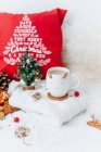 Чашка чаю та різдвяних прикрас поруч з подушкою — стокове фото