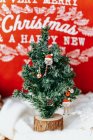 Árbol de Navidad en miniatura frente a una almohada - foto de stock