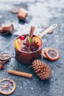 Mulled wine with spices and cinnamon sticks on a wooden background. selective focus. — Stock Photo