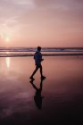 Garçon marchant sur la plage au coucher du soleil, Dana Point, Californie, USA — Photo de stock