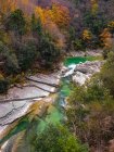 Vue aérienne d'une vallée fluviale alpine à travers une forêt d'automne, Apennins, Italie — Photo de stock