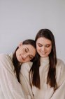 Portrait of two smiling sisters on white background — Stock Photo