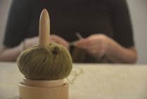 Desbobinador de lã em uma mesa na frente de uma mulher de tricô — Fotografia de Stock