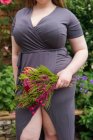 Женщина, стоящая в саду с кучей цветов, Англия, Великобритания — стоковое фото