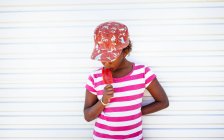 Retrato de una chica comiendo un caramelo de hielo - foto de stock