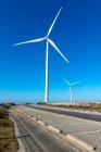 Windmill on the road in bright sunlight with blue sky — Stock Photo