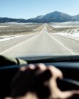 Car driving along an empty road towards mountains, Utah, Stati Uniti — Foto stock