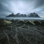 Personne debout sur une colline près de la montagne Vestrahorn, péninsule de Stokksnes, Islande — Photo de stock