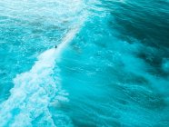Superficie de agua azul con espuma en el mar - foto de stock