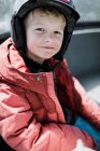 Portrait of a smiling boy sitting in a gondola wearing a skiing helmet, Mammoth Lakes, California, United States — Stock Photo