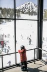 Junge in Skibekleidung blickt durch ein Fenster, Mammoth Lakes, Kalifornien, Vereinigte Staaten — Stockfoto