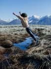 Мальчик, прыгающий через ручей, озеро Маммот, Калифорния, США — стоковое фото