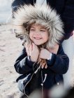 Ritratto di una madre che abbraccia sua figlia indossando una giacca finta con cappuccio di pelliccia, Palm Springs, California, Stati Uniti — Foto stock