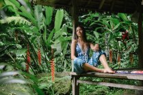 Frau sitzt unter einem Unterstand im Dschungel, Bali, Indonesien — Stockfoto