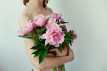 Gros plan d'une jeune femme tenant un bouquet de pivoines — Photo de stock